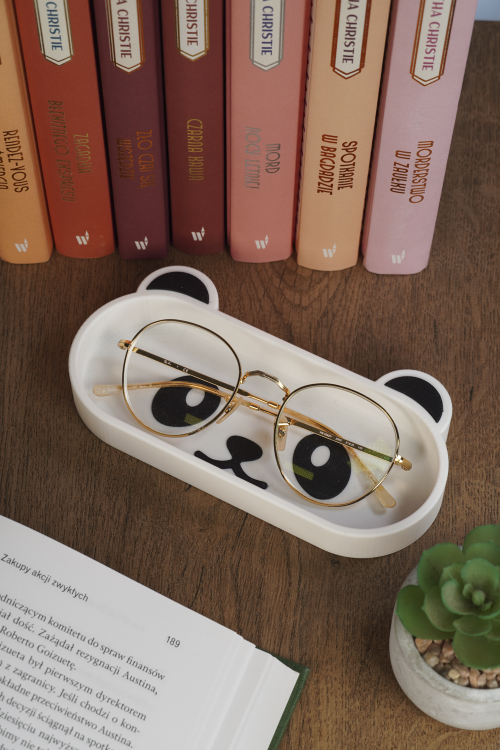 podstawka na okulary panda na półce z książkami